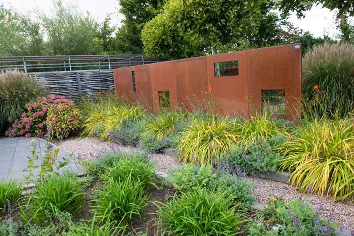 A metal partition in a garden with corten steel